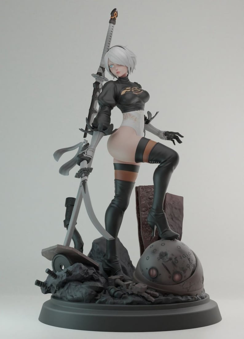 Op de afbeelding: Een vrouwelijke action figure met wit haar, gekleed in een zwart-witte outfit, die een zwaard vasthoudt. De figuur staat op een basis met een metalen bol en ander puin.