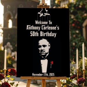 Op de afbeelding: Een zwart bord op een houten ezel met de tekst "Welcome To Anthony Corleone's 50th Birthday" en de datum "November 17th, 2025". Het bord toont een portret van een man in smoking met een rode roos. Rode rozen en kaarsen omringen het bord.