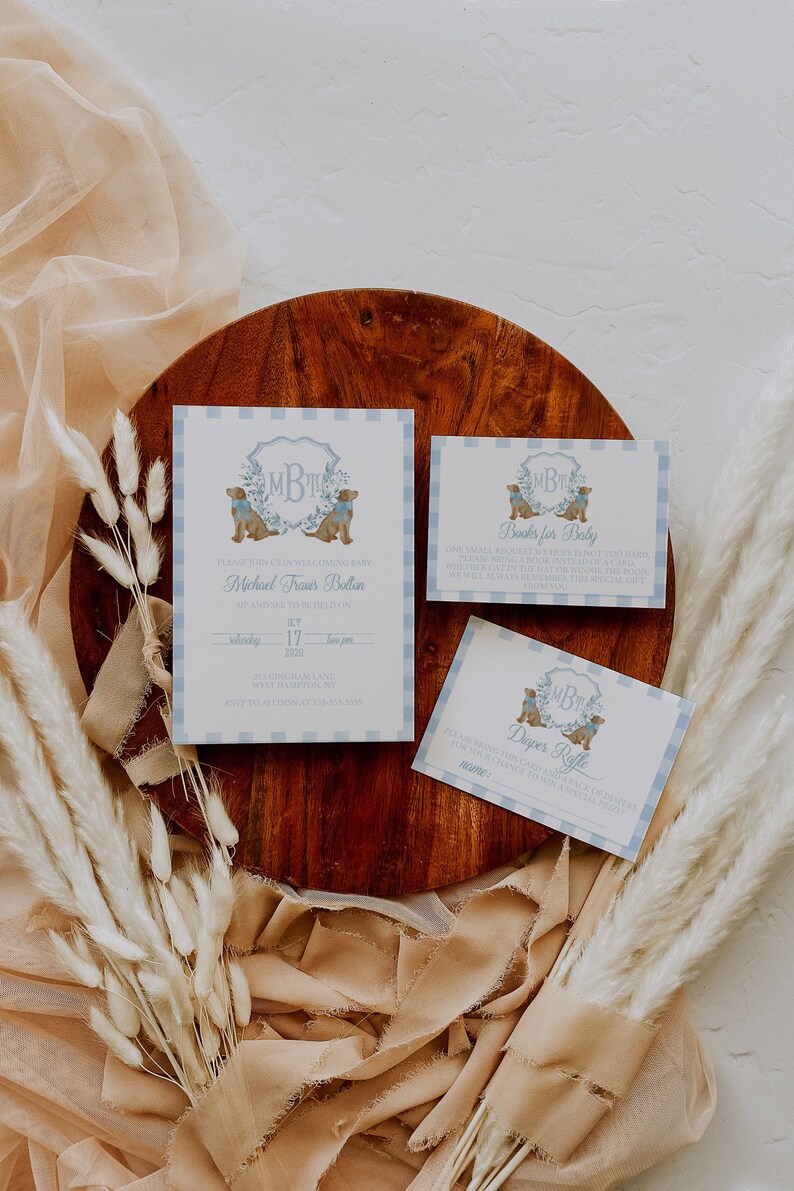 May include: A set of three baby shower invitations with a blue and white gingham pattern. The invitations feature a monogram with the initials "MBT" and a pair of brown dogs wearing blue bow ties. The text on the invitations reads "Please join us in welcoming baby Michael Traves Bolton", "Books for Baby", and "Diaper Raffle".