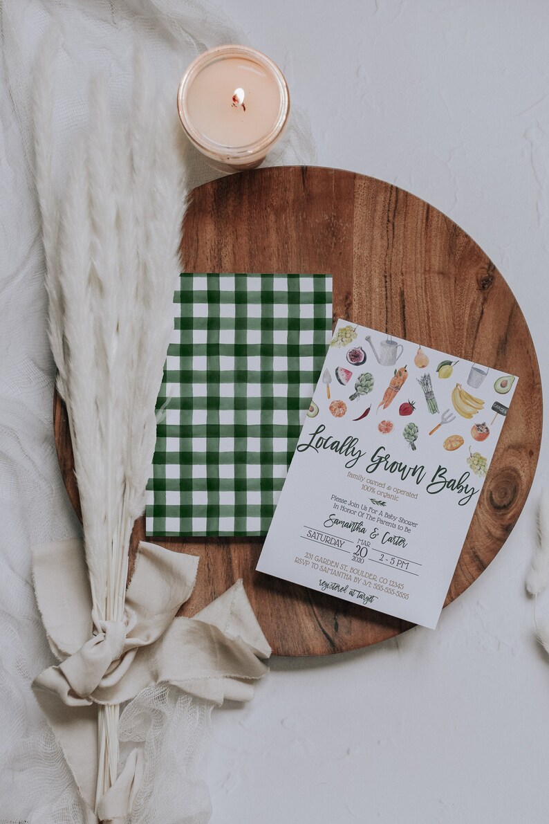 May include: A white card with green and white checkered paper behind it. The card is a baby shower invitation with the text "Locally Grown Baby" and the text "Please join us for a baby shower in honor of the parents to be Samantha & Carter" and the date "Saturday, March 20, 2020, 2-5 PM". The card is decorated with a watercolor illustration of various fruits and vegetables.