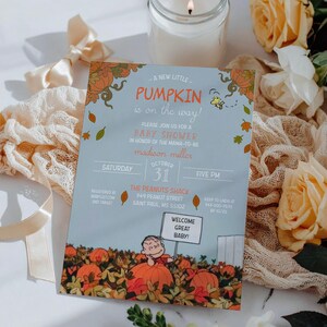 May include: A baby shower invitation with a light blue background and orange pumpkin illustrations. The invitation includes the text "A New Little Pumpkin is on the Way!" and features a cartoon of Charlie Brown holding a sign that says "Welcome Great Baby!"