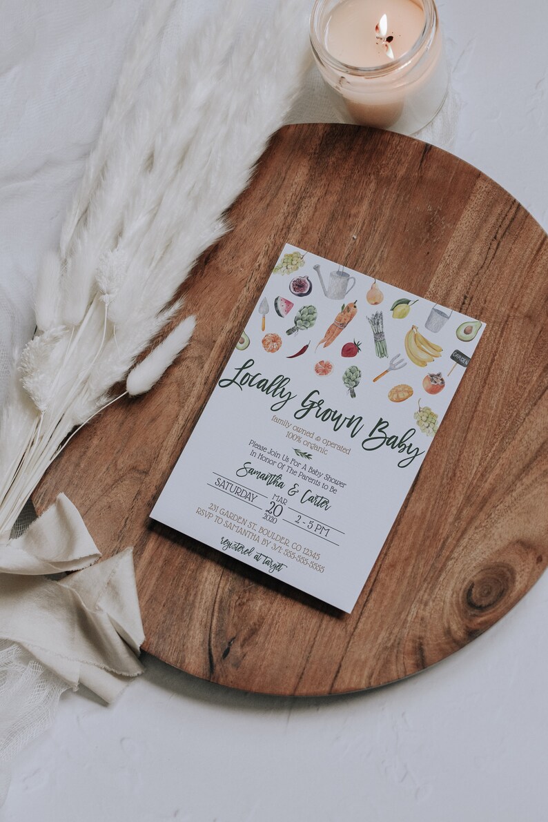 May include: A white card with a watercolor illustration of various fruits and vegetables. The text on the card reads "Locally Grown Baby, family owned & operated, 100% organic". The card also includes the text "Please Join Us For A Baby Shower In Honor Of The Parents To Be, Samantha & Carter, Saturday, March 20, 2020, 2-5 PM, 231 Garden St. Boulder, CO 12345, RSVP to Samantha by 3/1 555-555-5555, registered at Target".