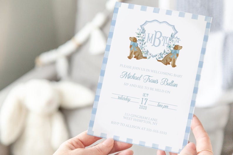May include: A blue and white gingham baby shower invitation with a monogram and two dogs. The invitation reads "Please join us in welcoming baby Michael Travis Bolton. Sip and see to be held on Saturday, October 17, 2020 at two pm. 213 Gingham Lane, West Hampton, NY. RSVP to Allison at 553-555-5553."