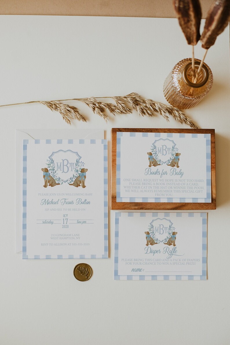 May include: A baby shower invitation with blue and white gingham pattern. The invitation features a watercolor illustration of two dogs with a monogram in the center. The text reads "Please join us in welcoming baby Michael Travis Bolton. Sip and see to be held on Saturday, October 17, 2020, two pm. 211 Gingham Lane, West Hampton, NY. RSVP to Allison at 555-555-5555."