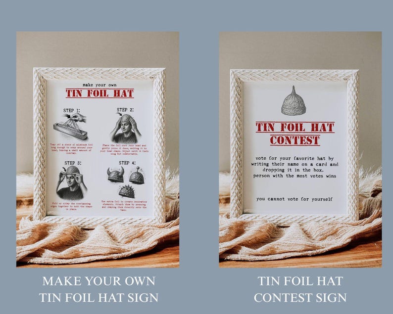 May include: Two framed signs with white woven frames. One sign reads "Make Your Own Tin Foil Hat" with step-by-step instructions. The other sign reads "Tin Foil Hat Contest" with contest rules. Both signs are on a wooden surface.