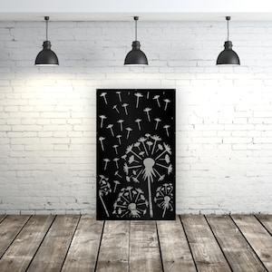 May include: A black metal wall art piece featuring a dandelion design. The artwork shows several dandelion seed heads with seeds blowing away. The piece is displayed against a white brick wall and wooden floor.