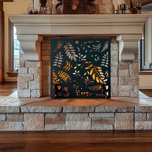 May include: A black metal fireplace screen with a leaf design. The screen is in front of a stone fireplace with a fire burning inside.