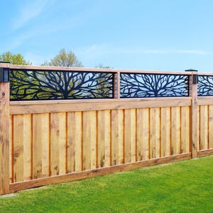May include: A wooden fence with a black metal tree design on top. The fence is made of horizontal wooden planks and the metal design is in the shape of a tree with branches.