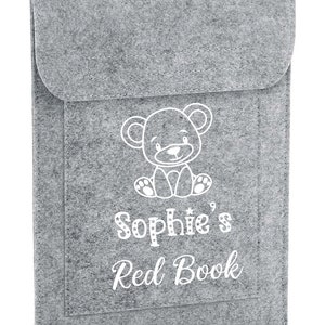 May include: Grey felt book sleeve with a white teddy bear design and the text "Sophie's Red Book".