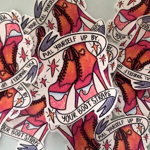 May include: A pile of stickers featuring a pair of red and white high-heeled shoes with the text "Pull yourself up by your boot straps". The stickers have a cartoon style and feature stars and hearts.