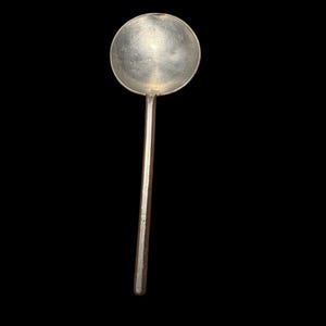 Peut inclure: Une cuillère en argent avec un bol rond et un long manche fin. La cuillère est faite d'un matériau métallique brillant et est posée sur un fond noir. Le bol de la cuillère est circulaire et de forme légèrement concave.