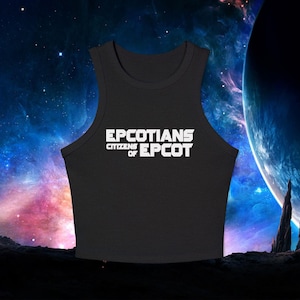 Puede incluir: Camiseta sin mangas negra con el texto blanco "EPCOTIANS CITIZENS OF EPCOT". La camiseta sin mangas tiene cuello redondo. El fondo presenta una escena espacial con planetas y estrellas.