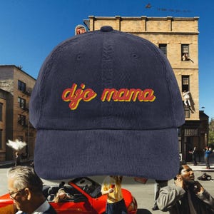 以下が含まれることがあります： イエローと赤で「djo mama」の刺繍が施された、ネイビーブルーのコーデュロイベースボールキャップ。カーブしたつばと丸みを帯びたトップが特徴です。普段使いにぴったりのスタイリッシュなアクセサリーです。