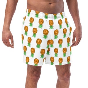 May include: White swim trunks with a pineapple print. The trunks have an elastic waistband with an internal drawstring, side pockets, and a mid-length fit. The fabric has a UPF 50+ rating.
