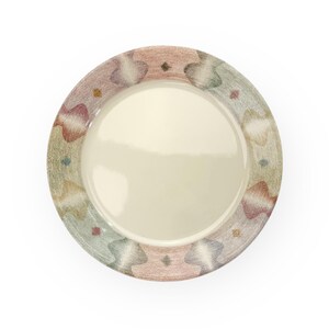 May include: A white ceramic plate with a colourful, abstract design around the rim. The design features shades of pink, green, blue, and brown.