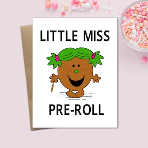 May include: A greeting card with the words "LITTLE MISS PRE-ROLL" in black block letters. The card features a cartoon character with a brown body, green hair, and a smiling face. The card is on a pink background.