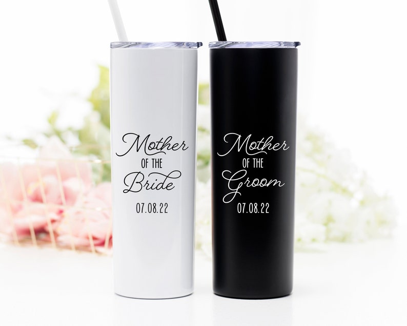 Your choice of mother of the bride or groom tumbler. 20 ounce stainless steel tumbler with lid and matching straw. Shown left to right: white mother of the bride tumbler personalized with wedding date. Matte black mother of the groom tumbler.
