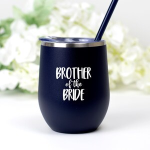 May include: A navy blue stainless steel tumbler with a white lid and a white inscription that reads "Brother of the Bride".