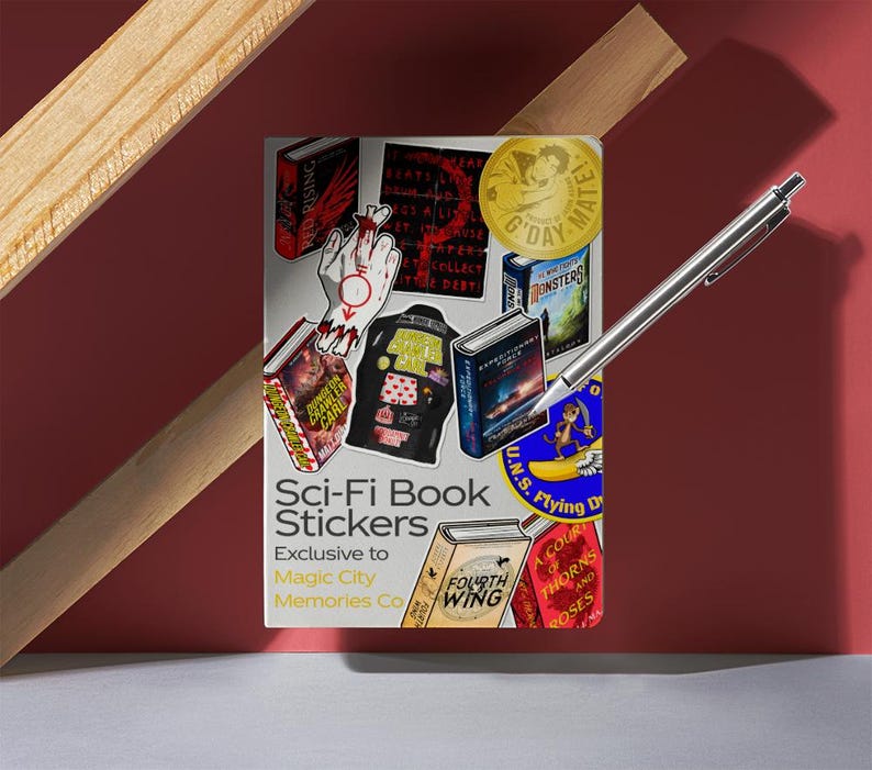 May include: A collection of Sci-Fi Book Stickers featuring various book covers and graphics. The stickers are exclusive to Magic City Memories Co. A silver pen rests on the stickers, with a red background and wooden accents.