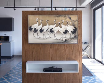 May include: A contemporary living room with a framed artwork showing white cranes with black details on a gold backdrop. The artwork is mounted on a wooden panel, above a white shelf with a black media device. The room has a blue and white tiled floor.