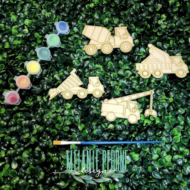 Puede incluir: Un conjunto de cinco recortes de veh&iacute;culos de construcci&oacute;n de madera con botes de pintura y un pincel. Los veh&iacute;culos incluyen una mezcladora de cemento, un cami&oacute;n volquete, una gr&uacute;a y otros dos camiones. Los botes de pintura son rojo, naranja, amarillo, verde y azul.