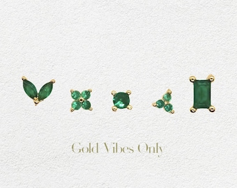May include: Five different gold earrings with green emerald gemstones. The earrings are in the shapes of a leaf, a square, a circle, a triangle, and a rectangle.