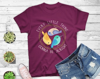 May include: Burgundy t-shirt with a white graphic of three birds in a nest. The text reads "Every little thing gonna be alright".