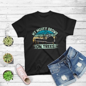 May include: Black t-shirt with a vintage-style graphic of a chainsaw cutting down a tree. The graphic says "My Money Grows On Trees".