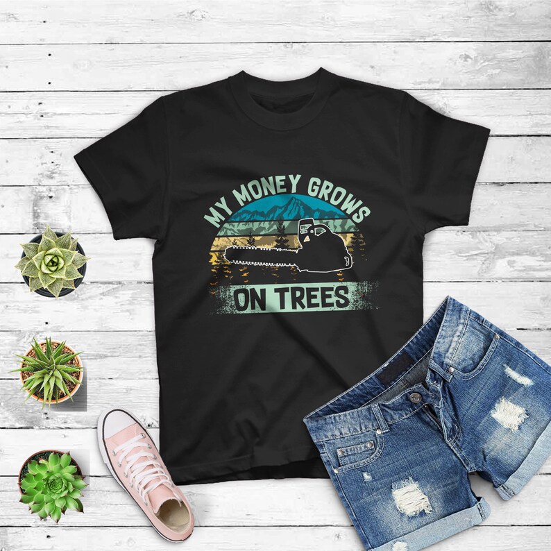 May include: Black t-shirt with a vintage-style graphic of a chainsaw cutting down a tree. The graphic says "My Money Grows On Trees".