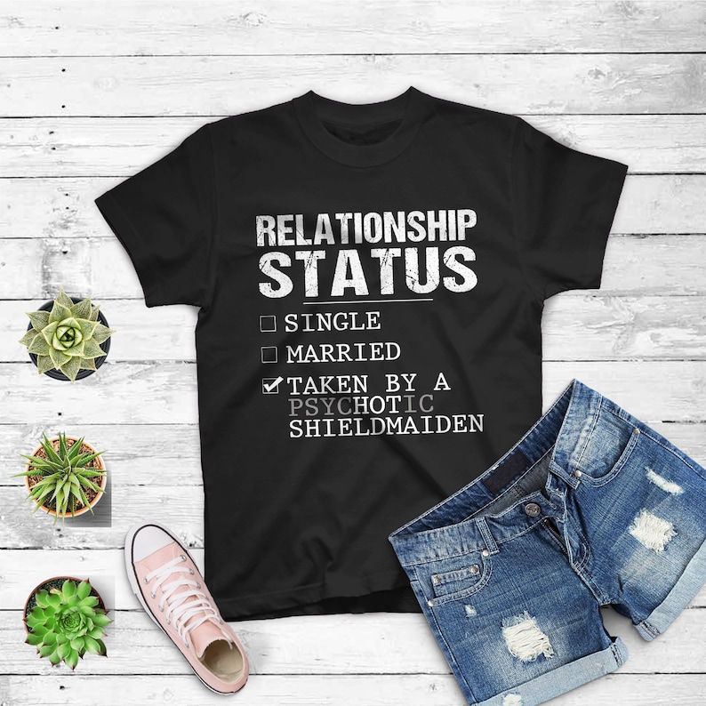 May include: Black t-shirt with white text that reads "Relationship Status" with checkboxes for "Single", "Married", and "Taken by a Psychotic Shieldmaiden". The "Taken by a Psychotic Shieldmaiden" box is checked.