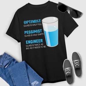 May include: Black t-shirt with a blue glass of water and text that reads "Optimist Glass is half full, Pessimist Glass is half empty, Engineer Glass is twice as big as it needs to be."