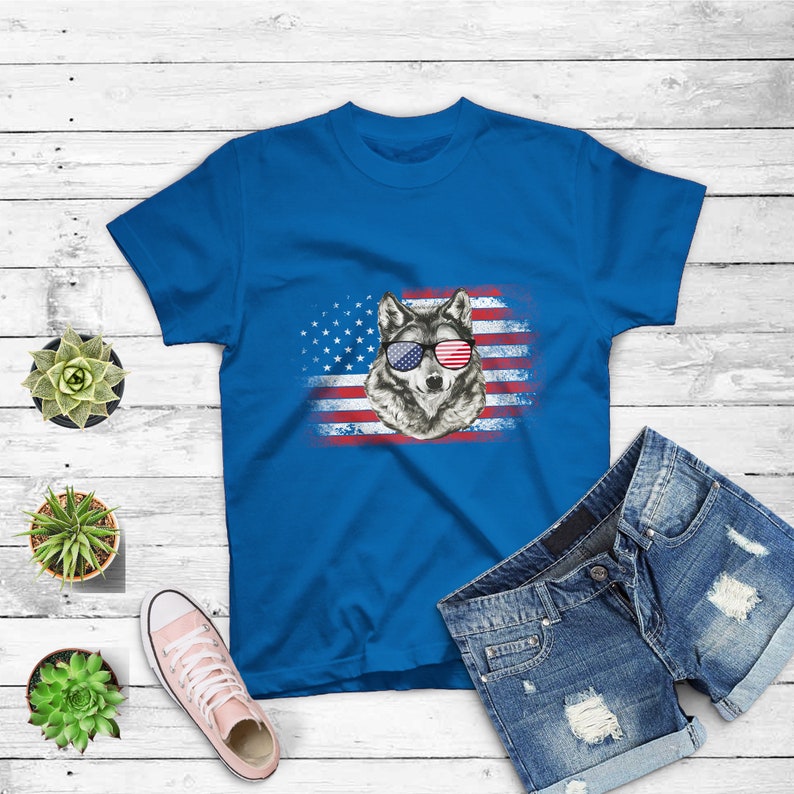 May include: A blue t-shirt with a wolf wearing red, white, and blue sunglasses in front of an American flag.