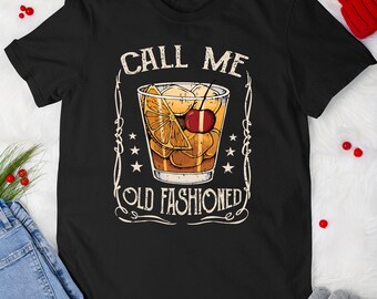 May include: Black t-shirt with a vintage-style illustration of an old fashioned cocktail. The text "Call Me Old Fashioned" is printed on the shirt.