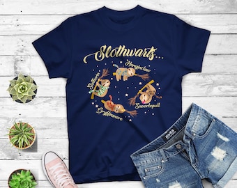 May include: A navy blue t-shirt with a gold graphic of four sloths on broomsticks. The sloths are labeled "Slytherin", "Gryffindor", "Hufflepuff", and "Ravenclaw". The text "Slothwarts..." is above the sloths.