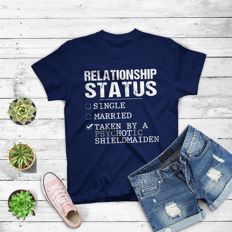 May include: Navy blue t-shirt with a white graphic that says "Relationship Status" with checkboxes for "Single", "Married", and "Taken by a Psychotic Shieldmaiden". The "Taken by a Psychotic Shieldmaiden" box is checked.