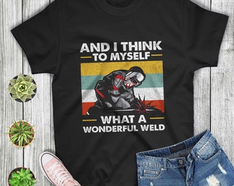 May include: Black t-shirt with a retro-style graphic of a welder and the text "And I think to myself - What a wonderful weld."
