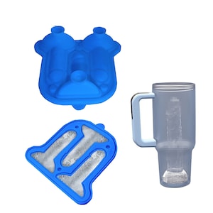 May include: Blue silicone ice cube tray with three different shaped molds. The tray is filled with ice. A clear plastic tumbler with a handle is filled with ice.