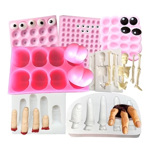 May include: Set of pink silicone molds for making various Halloween-themed treats, including eyeballs, hearts, and a skeleton. Also included are white silicone molds for making fingers and a hand.