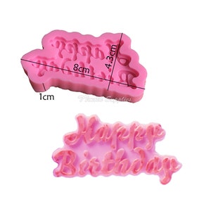 May include: Pink silicone mold for baking or crafting. The mold is shaped like the words "Happy Birthday" and measures 8 inches by 4.3 inches.