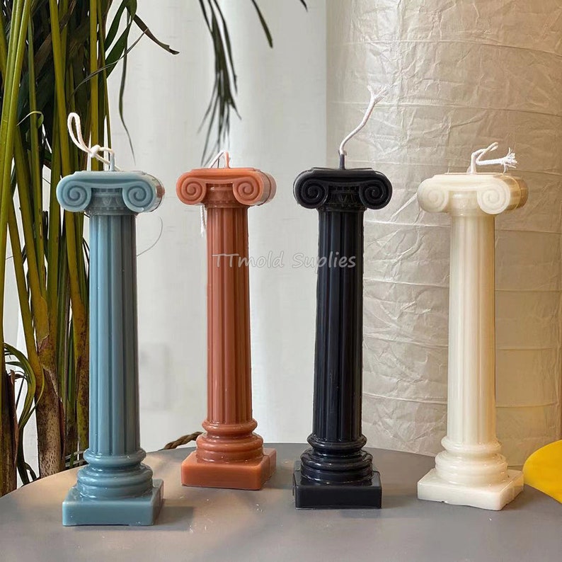 Puede incluir: Cuatro velas pilares decorativas en diferentes colores: azul, marr&oacute;n, negro y blanco. Las velas tienen forma de columnas romanas antiguas con detalles intrincados.