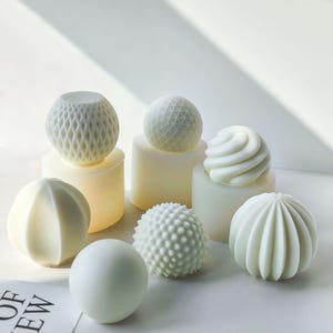 Puede incluir: Un conjunto de diez portavelas decorativos blancos en varias formas geométricas, incluyendo una esfera, un remolino y un diseño texturizado. Los portavelas están hechos de un material blanco liso y son perfectos para agregar un toque de elegancia a cualquier hogar.