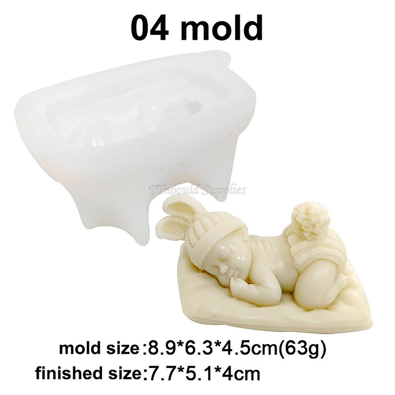May include: A white silicone mould for making a sleeping baby figurine. The mould is 8.9 cm by 6.3 cm by 4.5 cm and weighs 63 grams. The finished figurine is 7.7 cm by 5.1 cm by 4 cm.