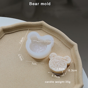 Puede incluir: Molde de silicona blanco en forma de oso con un di&aacute;metro de 7 cm y una altura de 7,8 cm. El molde se muestra con una vela blanca en forma de oso de 6,3 cm de ancho y 5,5 cm de alto. La vela pesa 35 gramos.