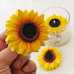 Puede incluir: Tres velas amarillas en forma de girasol con centros negros. Las velas son perfectas para agregar un toque de naturaleza a la decoración de tu hogar.