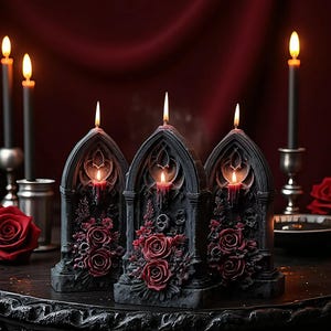 Puede incluir: Tres velas negras de estilo gótico con arreglos florales de rosas rojas. Las velas están encendidas, con un brillo cálido. Velas negras adicionales y una rosa roja en el fondo, creando un ambiente oscuro y romántico.