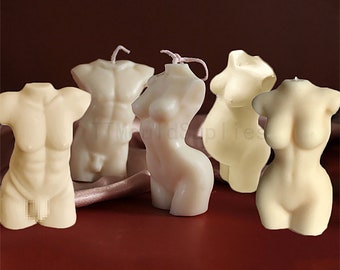 May include: Set of five nude-colored candles shaped like human torsos. The candles are made of wax and have a smooth, matte finish.