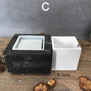 May include: A white silicone mold for making square planters. The mold is 8.5 inches wide and 8.5 inches long.