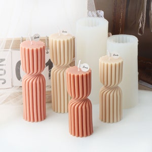 May include: Four twisted candle moulds, two in beige and two in orange, with the word "Smile" on each. The moulds are made of silicone and are designed to create candles with a unique twisted shape.
