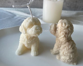 May include: Two dog-shaped candles, one white and one beige, are sitting on a white surface. The white candle has a wick with a string attached to it. The candles are detailed with fur and have a realistic appearance.