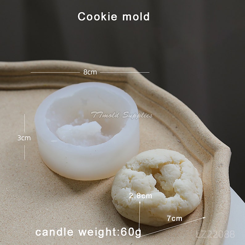 Puede incluir: Molde de galletas de silicona blanco con una profundidad de 3 pulgadas y un di&aacute;metro de 8 pulgadas. El molde se muestra con una galleta blanca que tiene 2,8 cm de di&aacute;metro y 7 cm de ancho. La galleta est&aacute; etiquetada como "peso de la vela: 60 g".